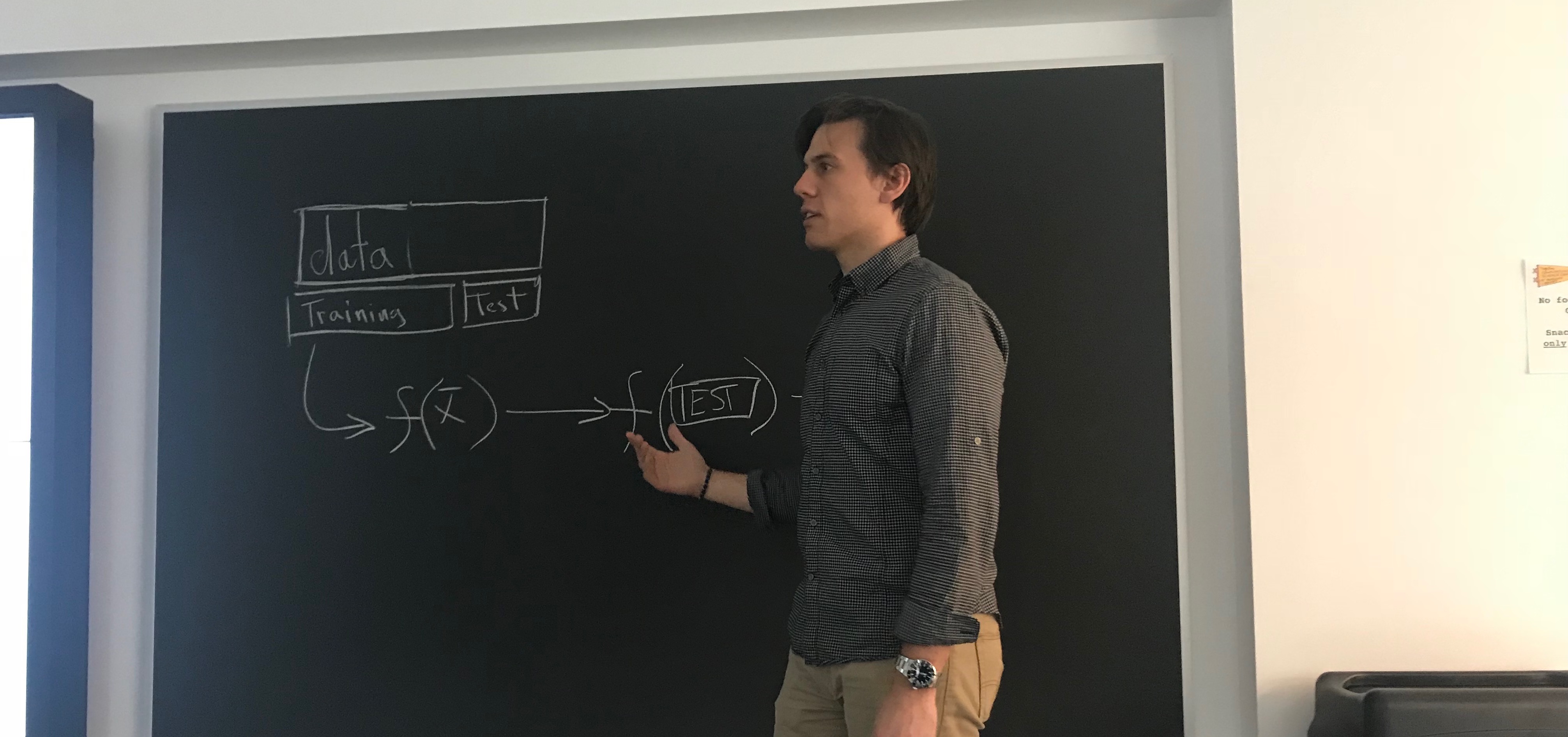 person teaching in front of blackboard, with a data-related diagram on it