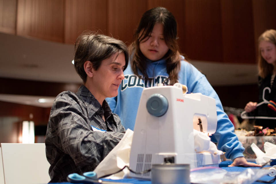 Professor demonstrates clothing repair at 2019 Women, Clothing, Climate event