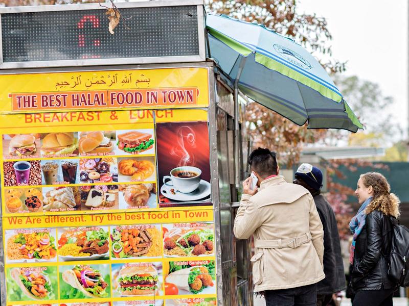 Halal food truck with colorful food posters and people in line
