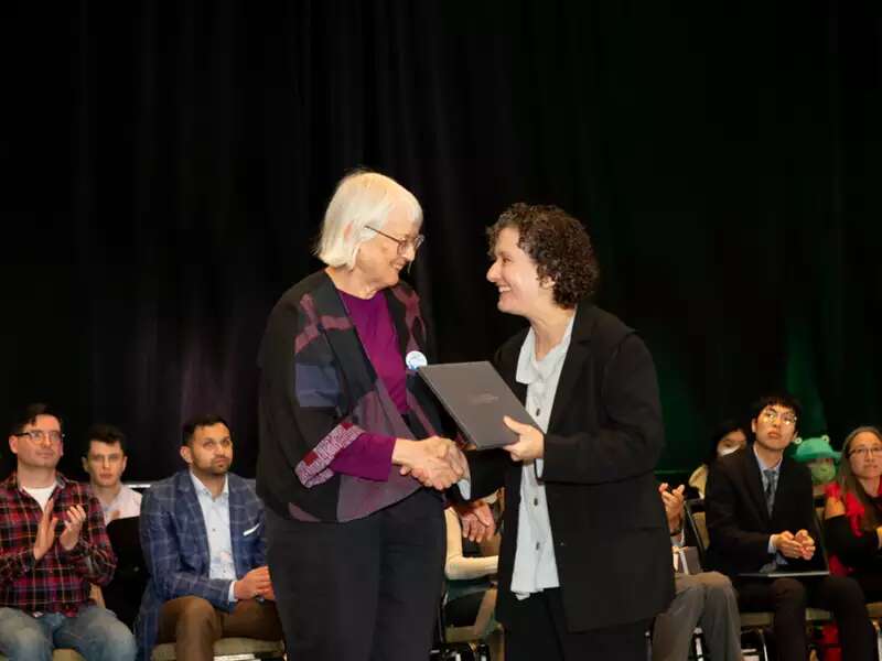 Dusa shaking hands during award
