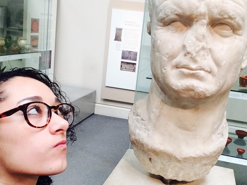 Student wrinkling her nose at a marble bust with a missing nose