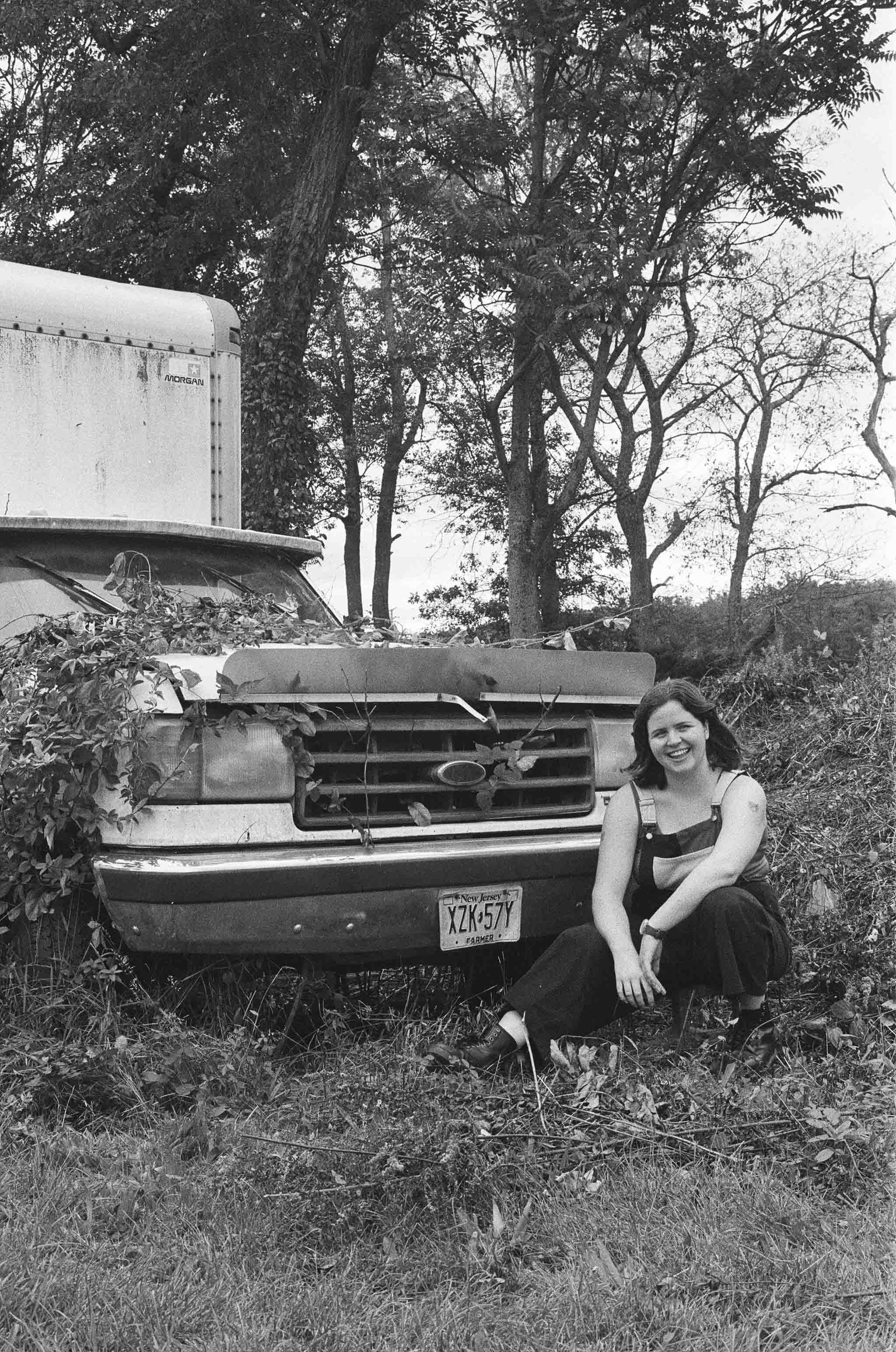 Black & White Image, Grace is smiling next to a car