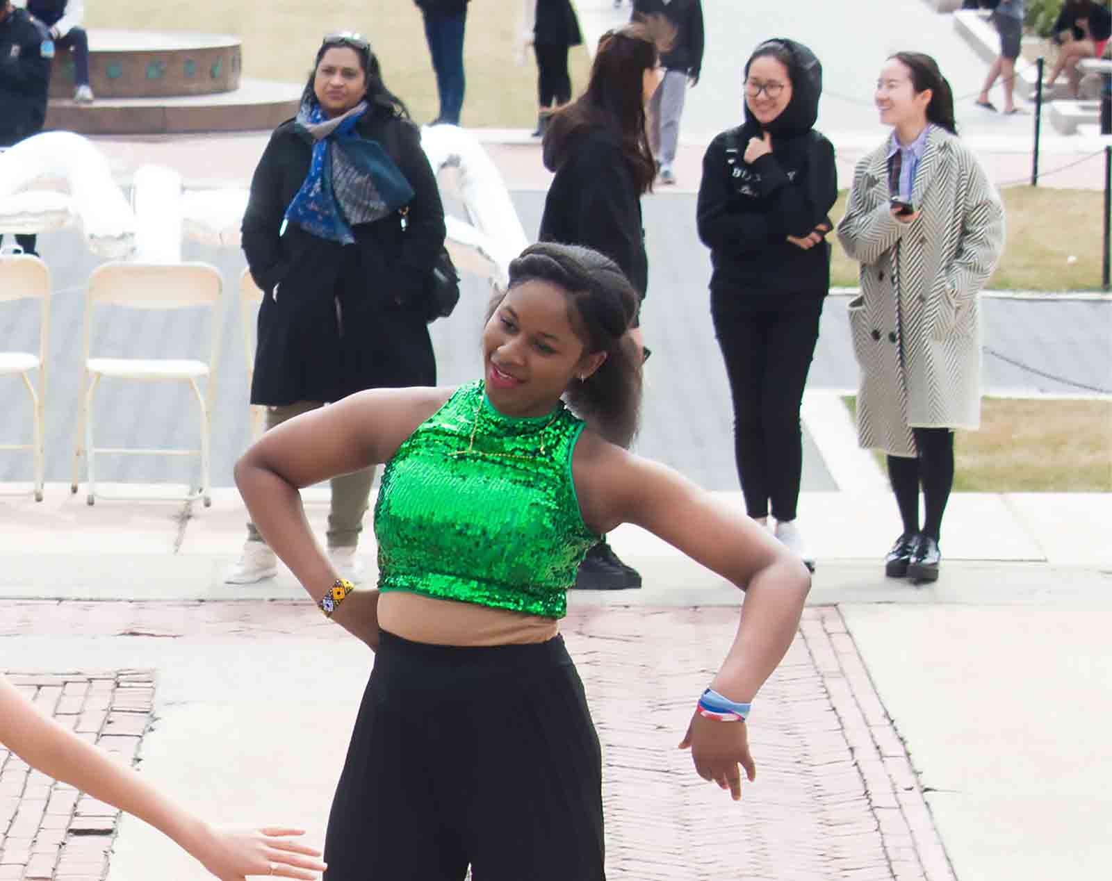 Young woman dancing wearing sequined green top
