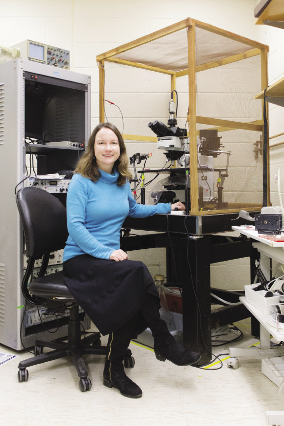 Elizabeth Bauer next to a microscope