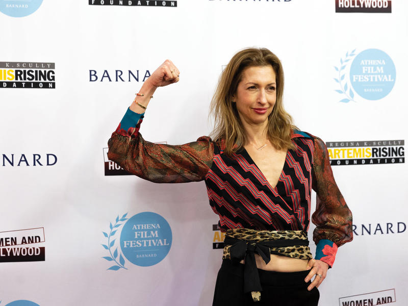 Woman flexing her arm muscle at the Athena Film Festival awards